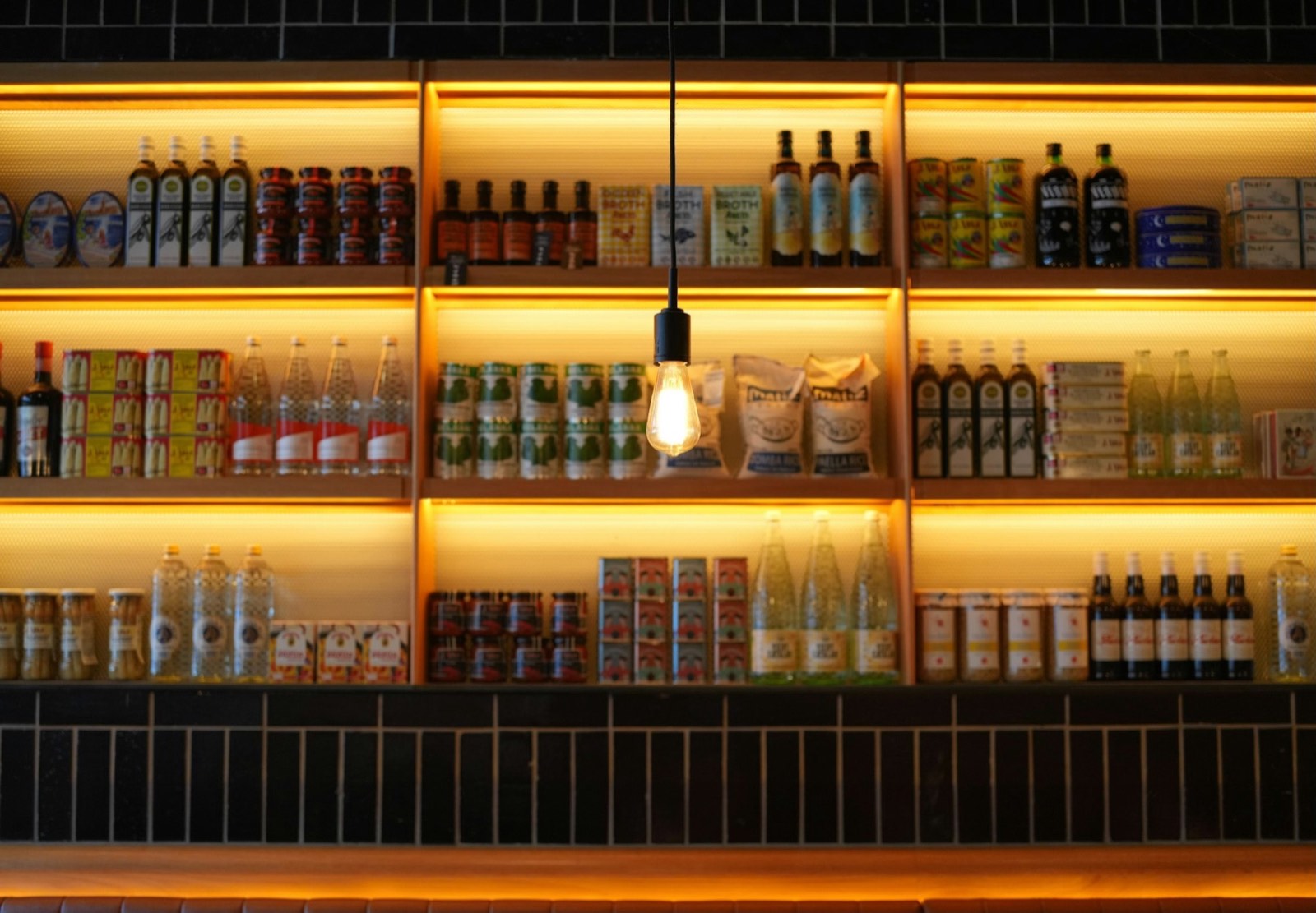 Warmly lit shop shelves stocked with everyday goods